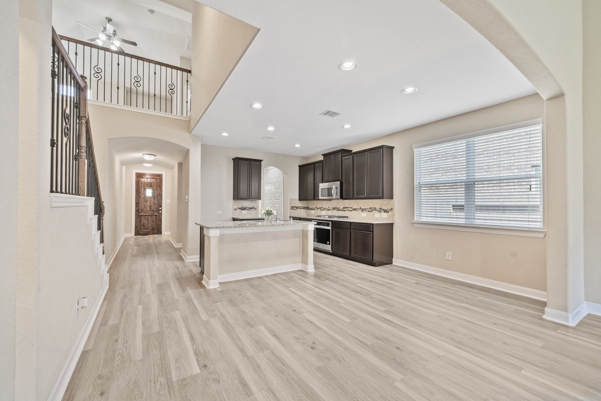 22523 Birch Ridge Meadow Drive Spring, TX 77389 - Photo 7 of 39 a large white kitchen with stainless steel appliances kitchen island a large counter top and a wooden floors