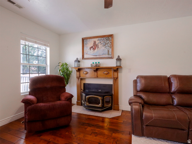 270 East 100 North Monroe, UT 84754 - Photo 10 of 65 Living area featuring wood-finish flooring, a wood-burning stove with a tile hearth, and a decorative wood mantelpiece