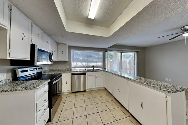 a large kitchen with stainless steel appliances granite countertop a stove a sink dishwasher and a refrigerator