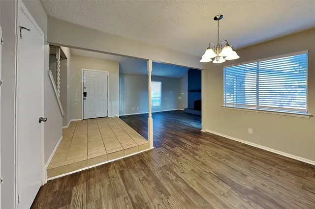 a view of a room with wooden floor and chandelier
