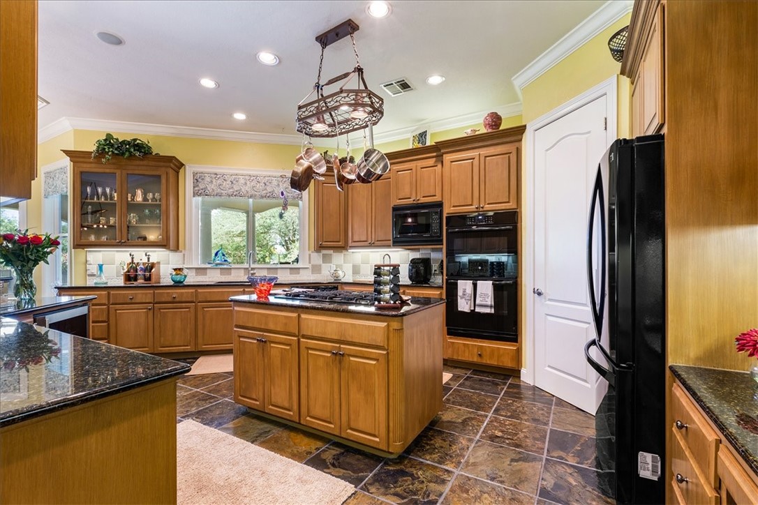 1021 Park Ridge Circle McGregor, TX 76657 - Photo 13 of 48 a kitchen with stainless steel appliances granite countertop a sink a stove and a refrigerator