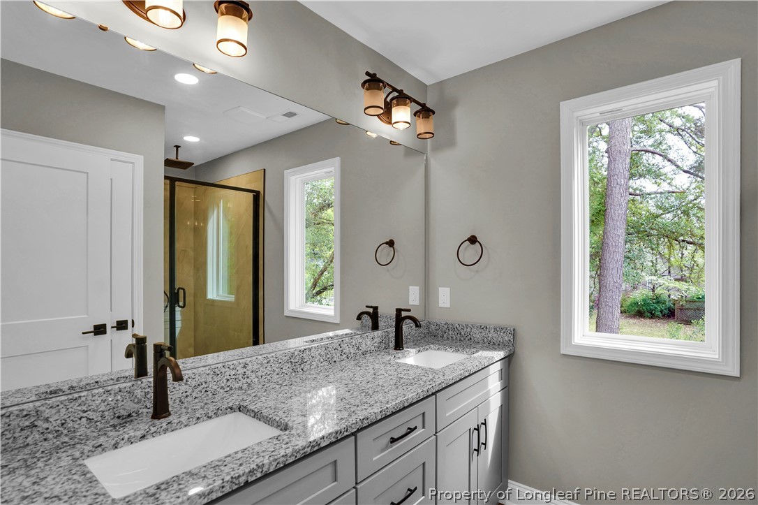 610 North Main Street Raeford, NC 28376 - Photo 22 of 28 a bathroom with a granite countertop sink and a mirror