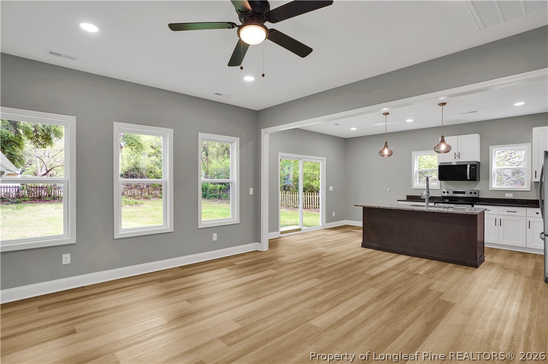 610 North Main Street Raeford, NC 28376 - Photo 7 of 28 a large kitchen with stainless steel appliances granite countertop a stove and a wooden floors