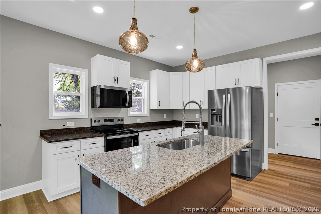 610 North Main Street Raeford, NC 28376 - Photo 10 of 28 a kitchen with stainless steel appliances granite countertop a sink refrigerator and microwave