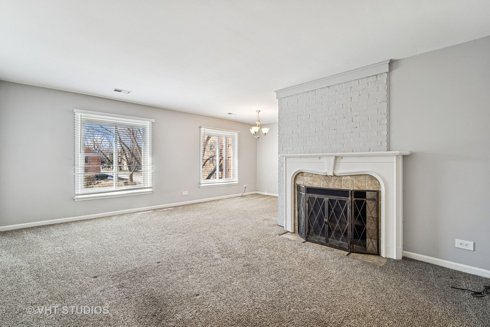 1499 Shermer Road, Unit 201E Northbrook, IL 60062 - Photo 4 of 16 a view of an empty room with a fireplace and a window
