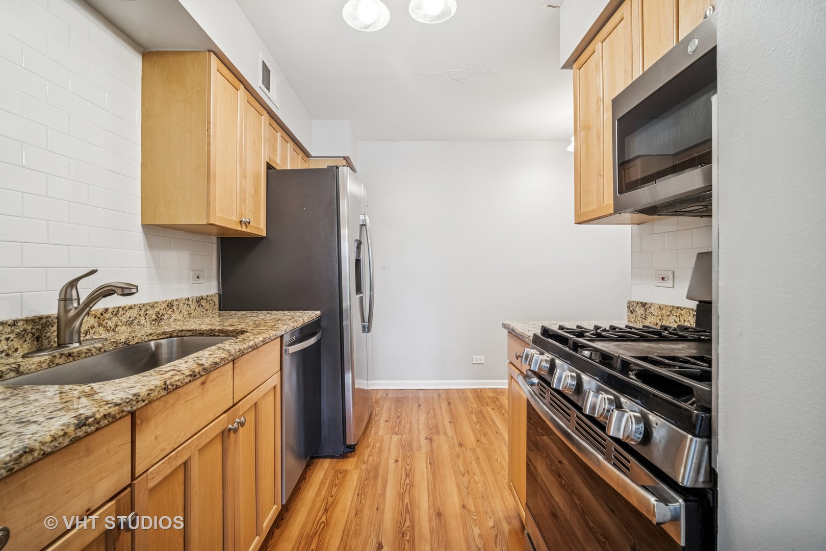 1499 Shermer Road, Unit 201E Northbrook, IL 60062 - Photo 7 of 16 a kitchen with granite countertop stainless steel appliances a sink stove top oven and cabinets