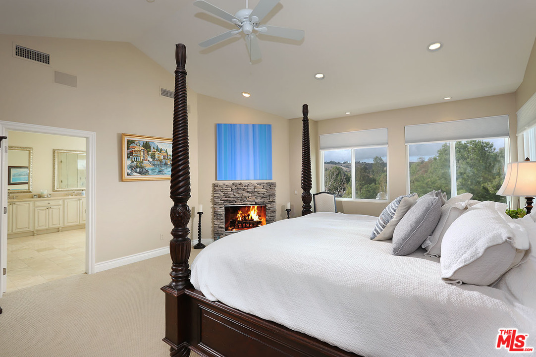 5845 Hilltop Road Hidden Hills, CA 91302 - Photo 10 of 16 a bedroom with a bed a window and potted plant on the dresser