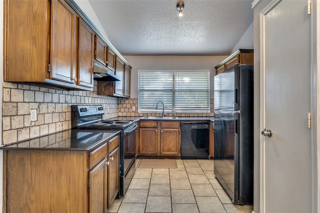 3820 River Birch Road Fort Worth, TX 76137 - Photo 4 of 22 a kitchen with stainless steel appliances granite countertop a stove a sink and a refrigerator