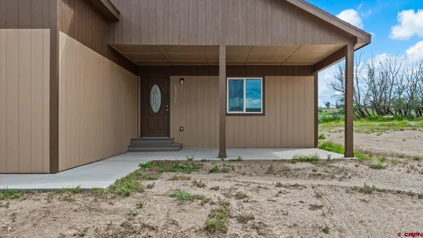 a view of empty room with wooden floor and window