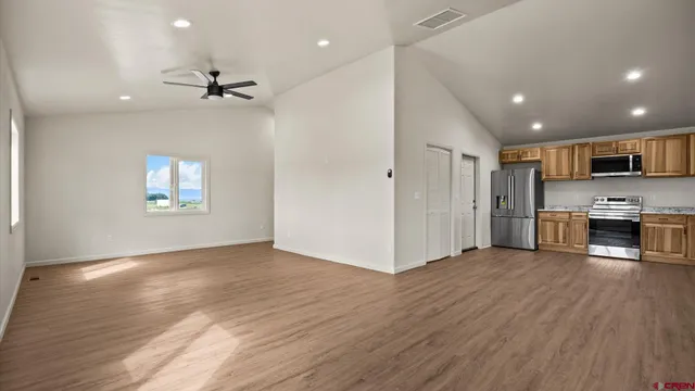 a large kitchen with stainless steel appliances granite countertop a stove and a refrigerator