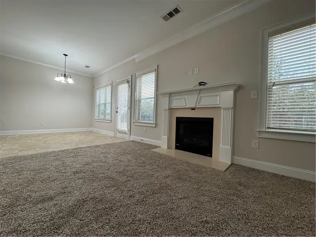 an empty room with windows and fireplace