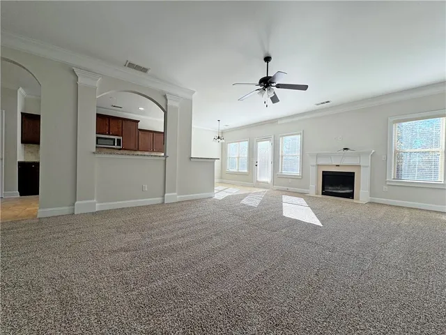 a view of empty room with fireplace and windows