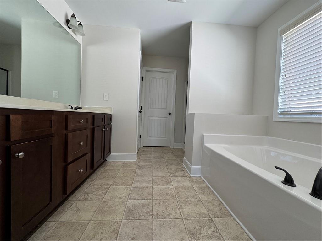 2251 Chance Lane Grayson, GA 30017 - Photo 20 of 35 a spacious bathroom with a tub sink and mirror