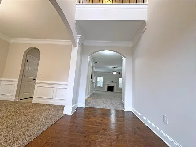 a view of a livingroom with wooden floor and a kitchen space