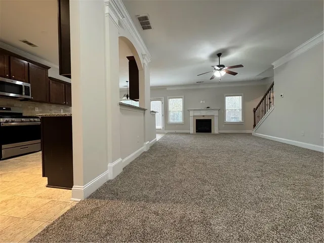 an empty room with windows and fireplace