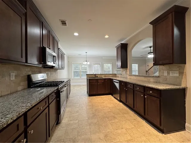 a large kitchen with stainless steel appliances and a sink