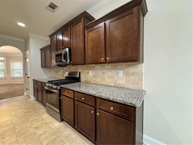 a kitchen with stainless steel appliances granite countertop a sink stove and cabinets