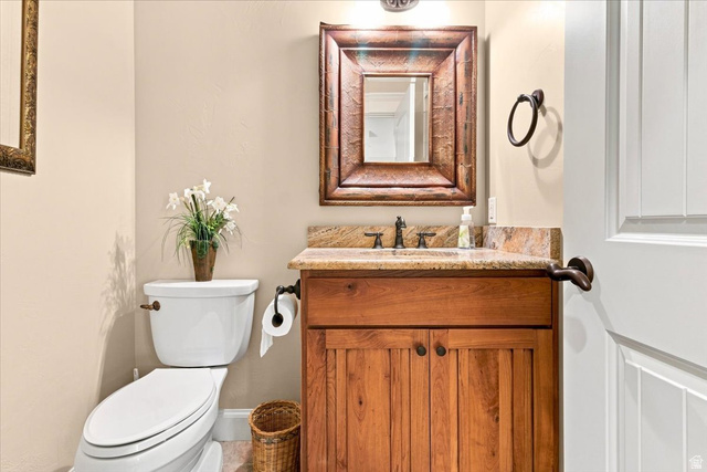 11290 South Southfield Road Mayfield, UT 84643 - Photo 60 of 103 Wood-finish vanity with a stone countertop, bronze faucet, and a framed mirror