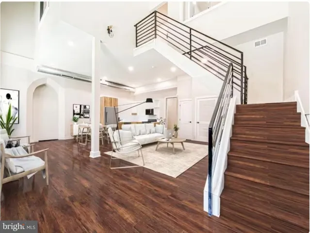 a dining room with wooden floor table and chairs