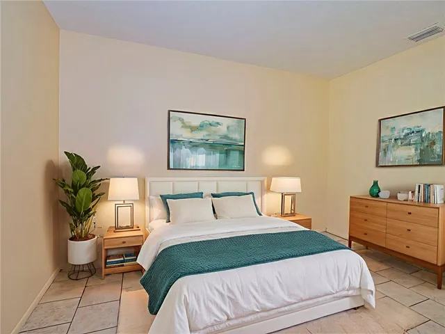 a bedroom with a bed and a potted plant