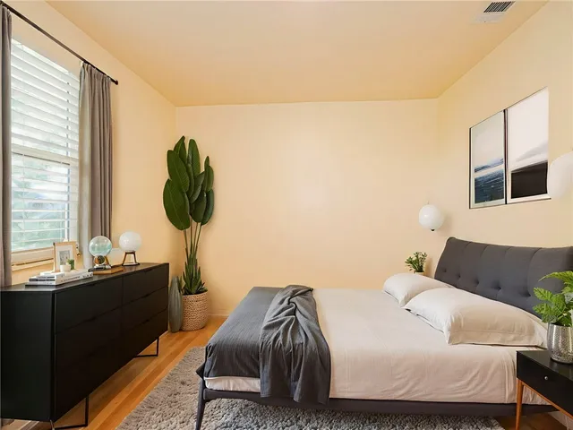 a bedroom with a bed and wooden floor