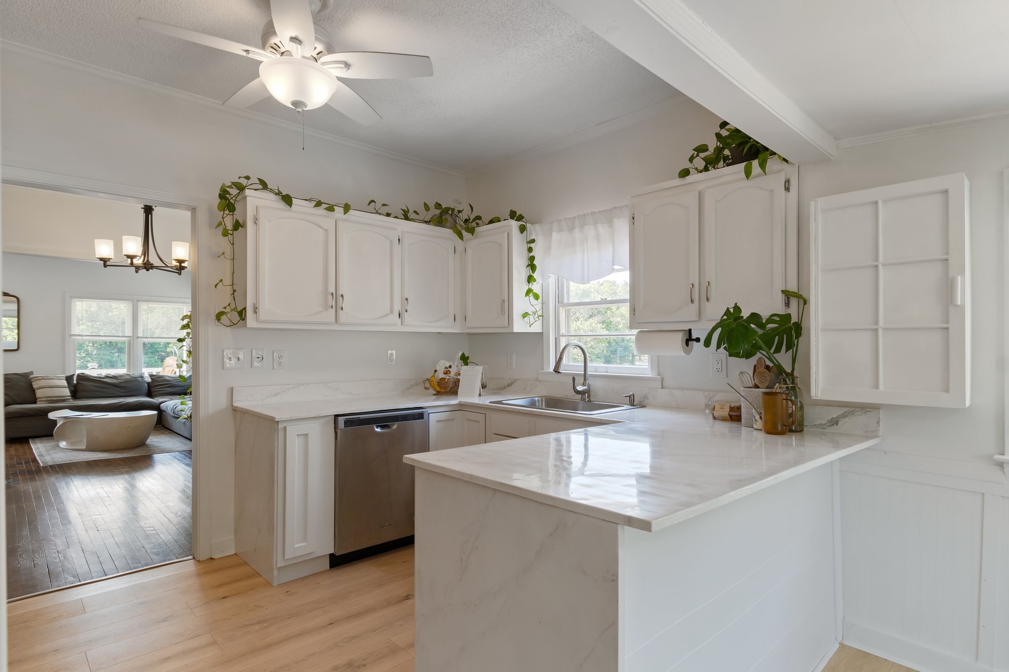4711 Ollie Chunn Road Spring Hill, TN 37174 - Photo 21 of 64 a kitchen with a sink dishwasher a stove and white cabinets with wooden floor