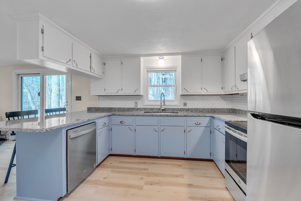 10 Blodgett Road Holland, MA 01521 - Photo 4 of 25 a kitchen with granite countertop cabinets stainless steel appliances a sink and a window