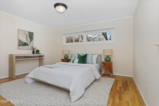 a bedroom with a bed and painting on the wall