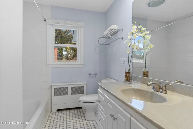 a bathroom with a sink a toilet and a mirror