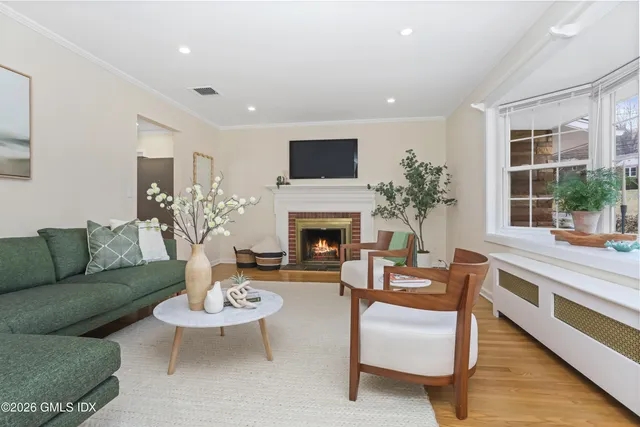 a living room with furniture fireplace and a large window