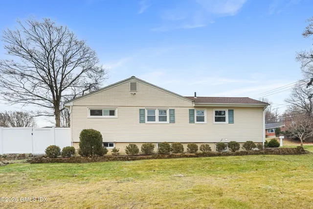a front view of house with yard and trees in the background