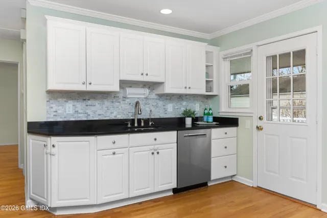a kitchen with granite countertop white cabinets and white appliances