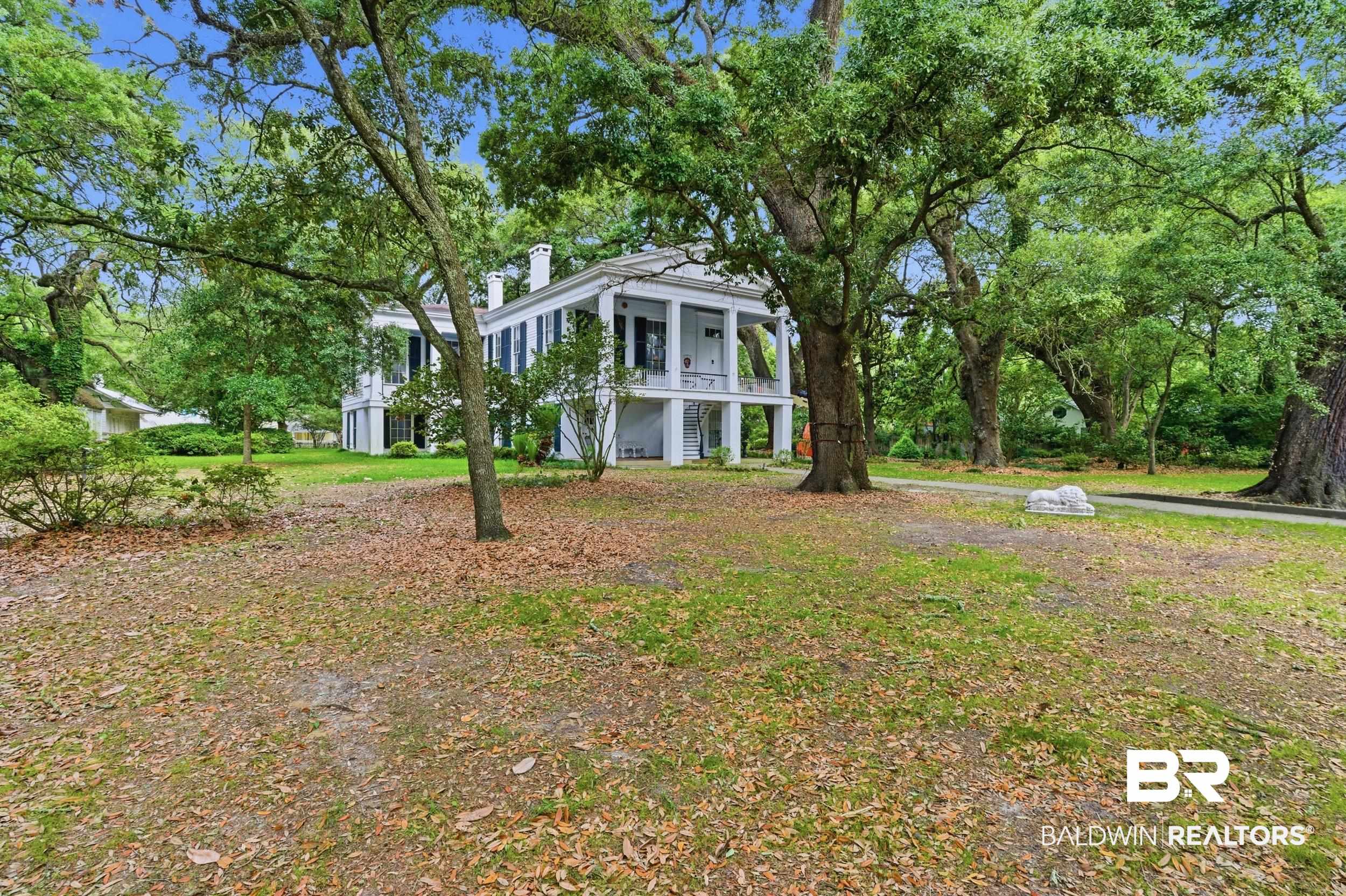 350 Charles Street Mobile, AL 36604 - Photo 45 of 52 Stately Colonial residence featuring a two-story portico with white columns, dark louvered shutters, and a classic white facade