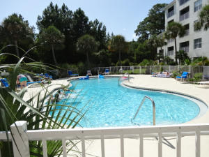 a swimming pool with outdoor seating and plants