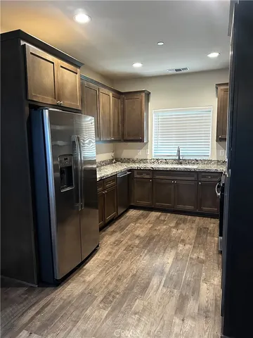 a kitchen with stainless steel appliances granite countertop a refrigerator a sink a stove a microwave and island