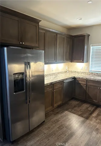 a kitchen with stainless steel appliances granite countertop a refrigerator a sink a stove and cabinets