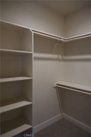 a view of walk in closet with empty racks