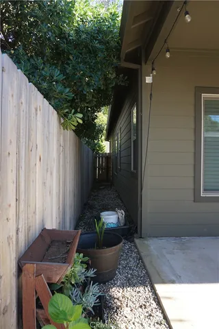 a backyard of a house with table and chairs under an umbrella