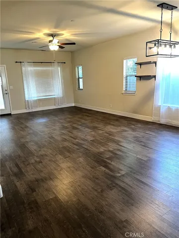 a view of a room with wooden floor kitchen view and windows