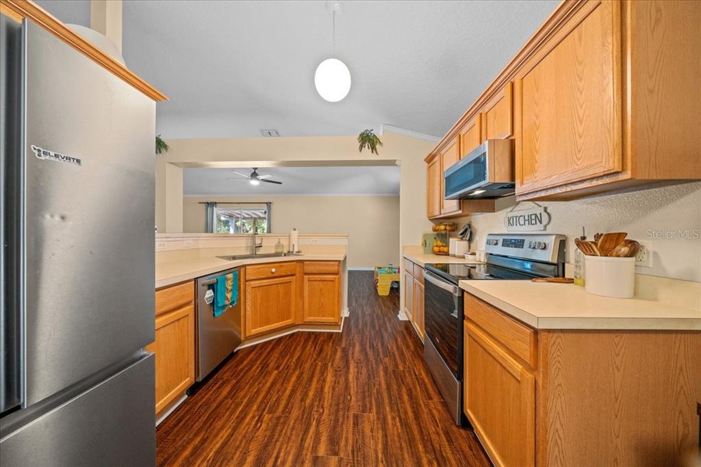49 Hemlock Radial Loop Ocala, FL 34472 - Photo 14 of 50 a kitchen that has a lot of cabinets a sink and wooden floor