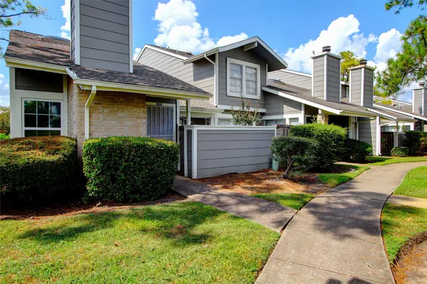 a front view of a house with a yard and potted plants