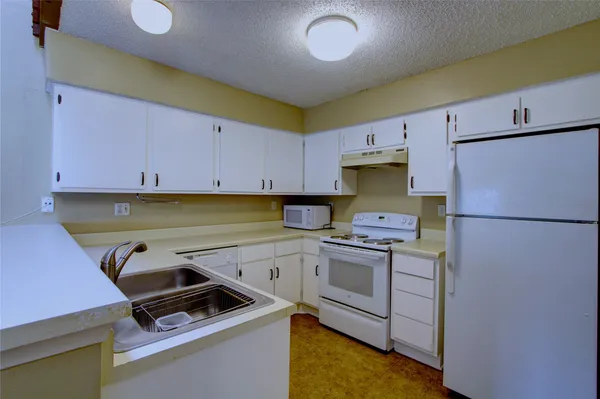 a kitchen with a stove a refrigerator and a sink