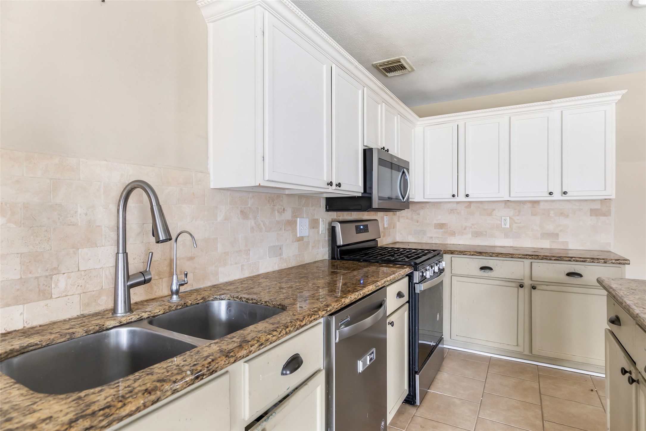 19226 Pinewood Mist Lane Humble, TX 77346 - Photo 11 of 33 a kitchen with granite countertop a sink a stove and cabinets
