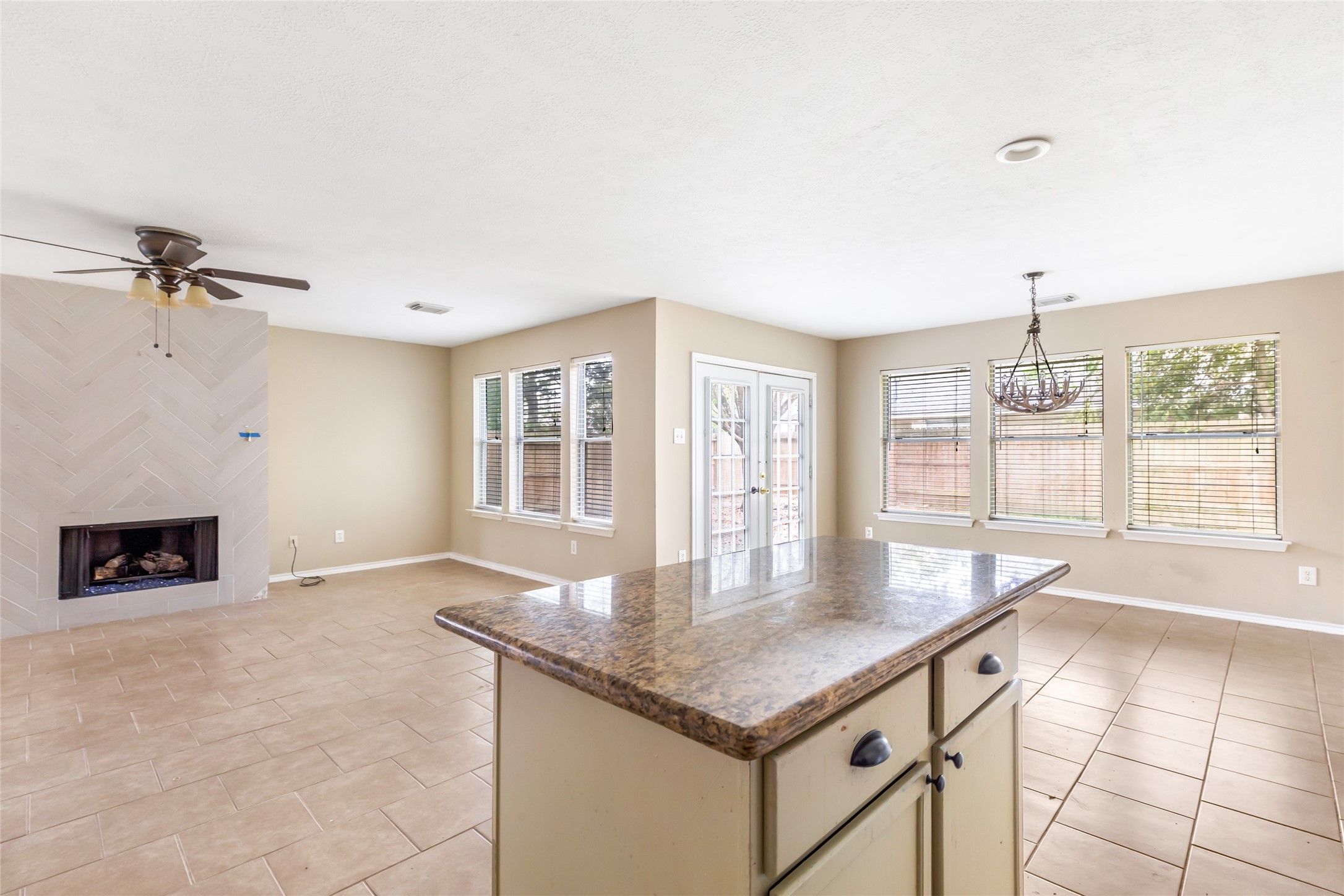19226 Pinewood Mist Lane Humble, TX 77346 - Photo 13 of 33 a kitchen with granite countertop a stove a sink and a dining table with chandelier