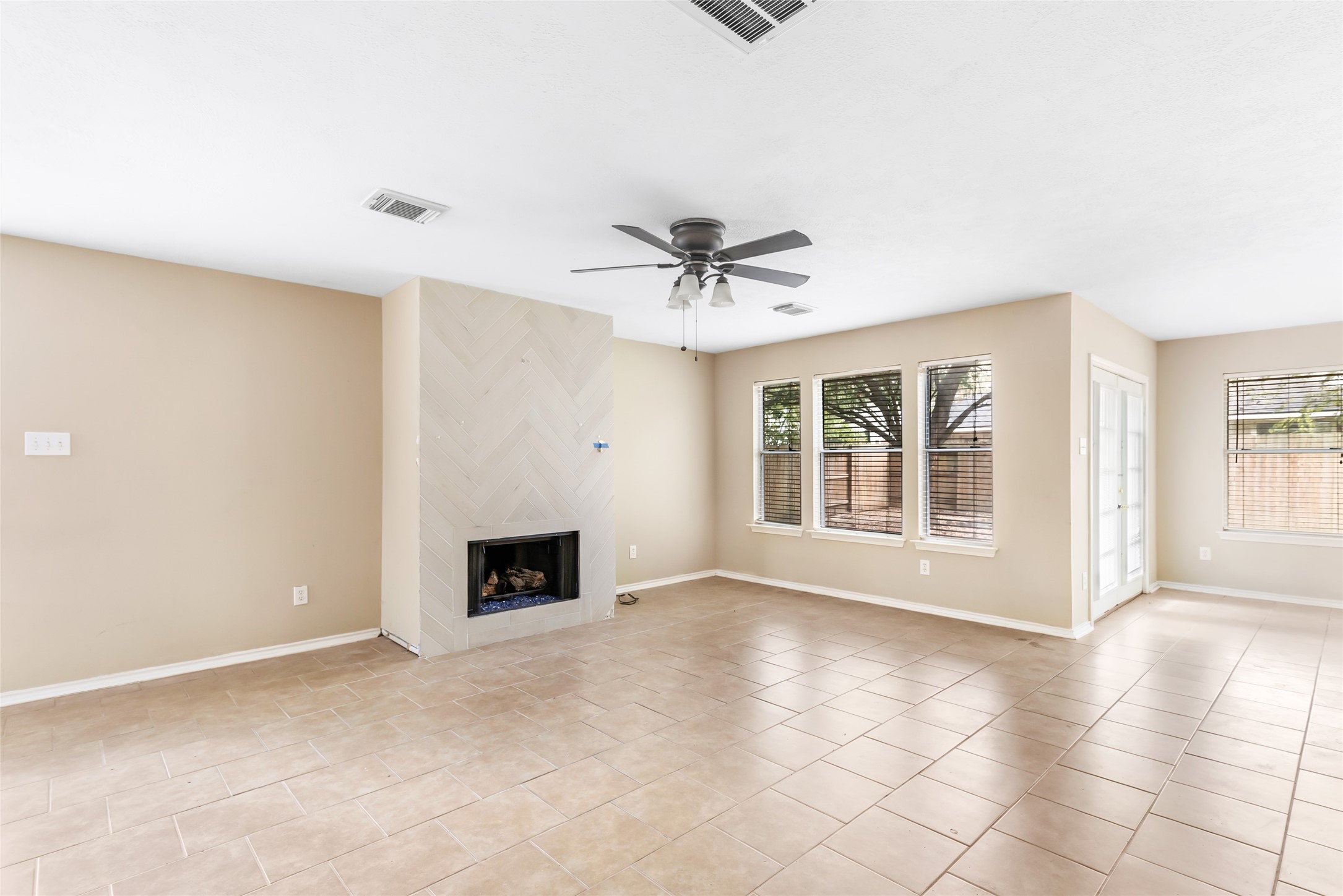 19226 Pinewood Mist Lane Humble, TX 77346 - Photo 16 of 33 a view of an empty room with a fireplace and a window