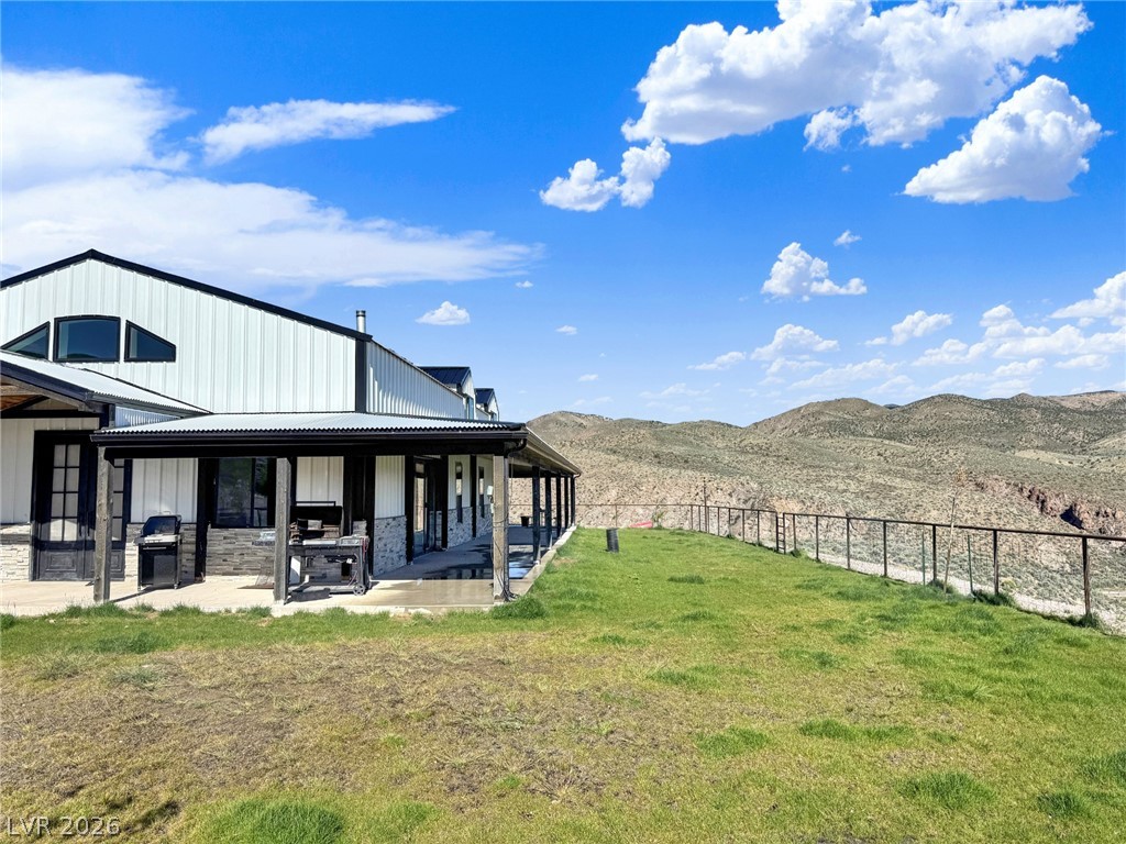 9393 North 93rd Highway Caliente, NV 89008 - Photo 8 of 41 A spacious covered patio invites relaxation, perfectly framed by verdant lawns and dramatic mountain vistas.