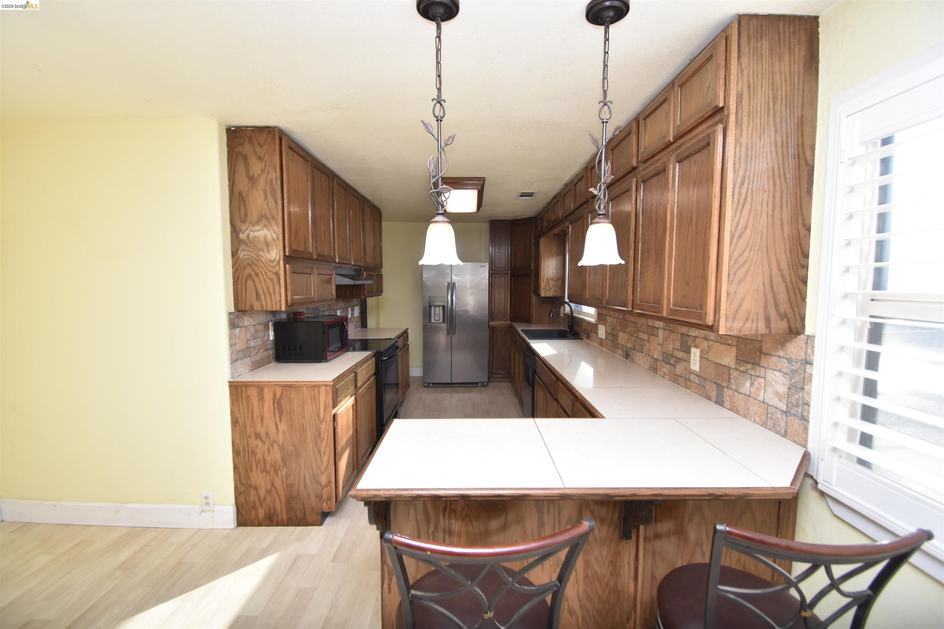 5100 Kiernan Avenue Salida, CA 95368 - Photo 24 of 45 a kitchen with stainless steel appliances kitchen island a table chairs in it and wooden floors