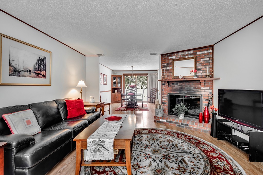 2 Kingman Road Acton, MA 01720 - Photo 2 of 28 a living room with furniture a flat screen tv and a fireplace