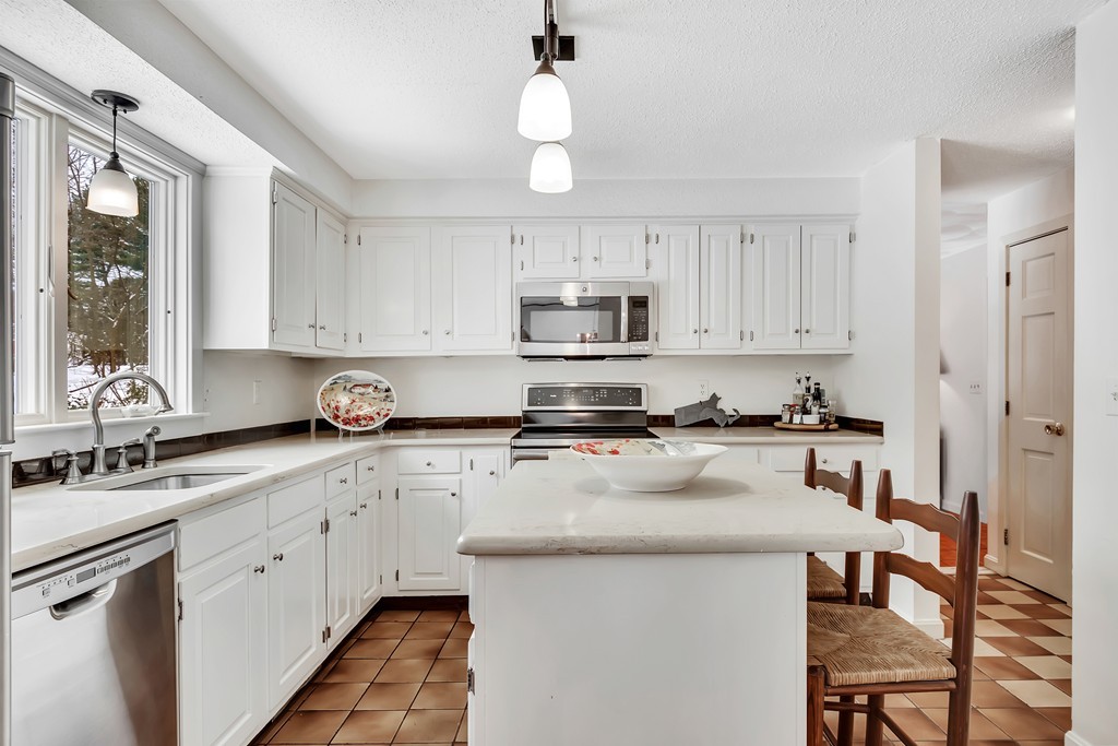 2 Kingman Road Acton, MA 01720 - Photo 7 of 28 a kitchen with kitchen island granite countertop a sink a counter space appliances and cabinets
