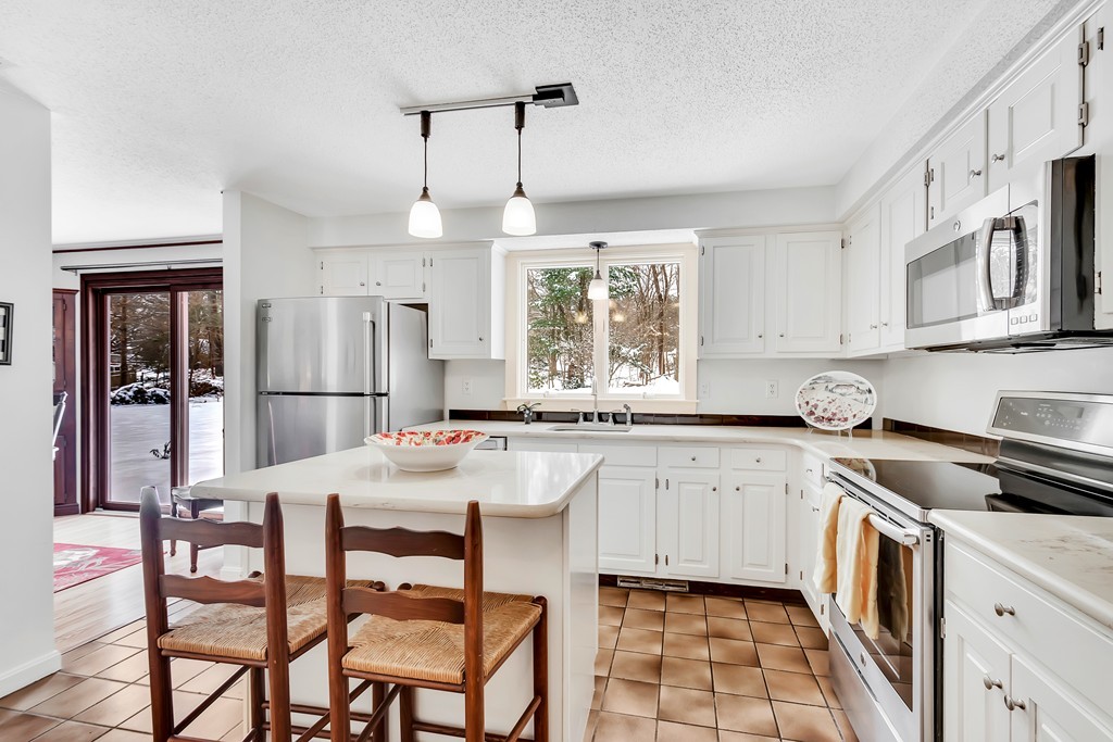2 Kingman Road Acton, MA 01720 - Photo 8 of 28 a kitchen with stainless steel appliances granite countertop a stove a sink dishwasher a stove a refrigerator with a dining table and chairs